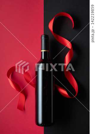 Bottle of red wine with satin ribbons. Bottle of red wine with satin ribbons. 142219859