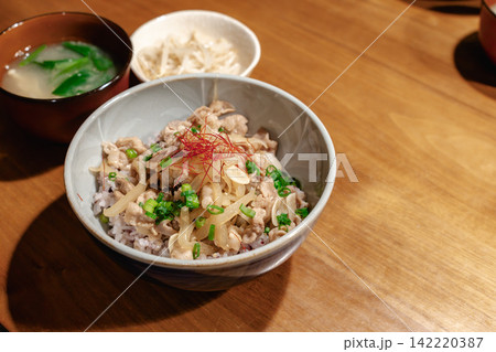 木製テーブルに置かれた豚肉丼定食 142220387