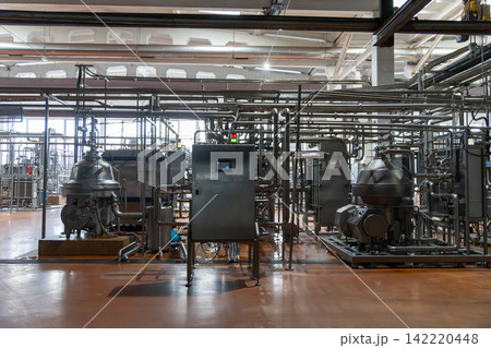 Modern dairy factory interior with stainless steel milk separators Modern dairy factory interior with stainless steel milk separators 142220448