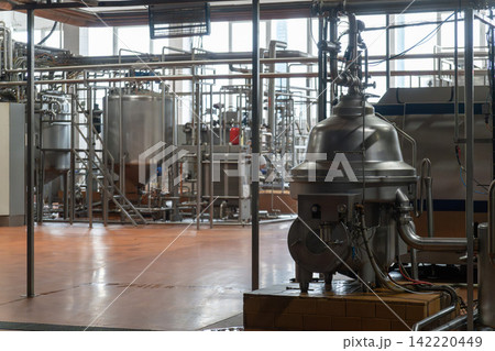 Industrial dairy plant interior with stainless steel separator machine 142220449