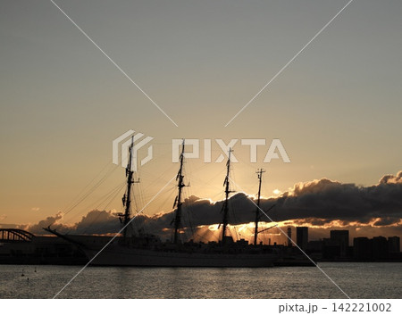 雲間から差し込む光と帆船日本丸の日の出 雲間から差し込む光と帆船日本丸の日の出 142221002