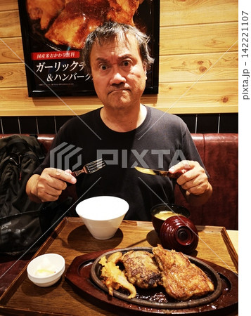 ガーリックチキン&ハンバーグを食べる男性 ガーリックチキン&ハンバーグを食べる男性 142221107
