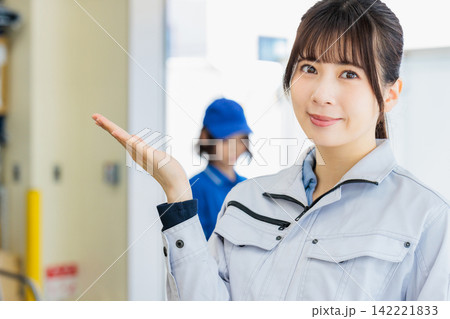 倉庫で作業服を着た働く女性 倉庫で作業服を着た働く女性 142221833