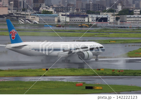 雨の滑走路に着陸する旅客機 エンジンの逆噴射の水煙 雨の滑走路に着陸する旅客機 エンジンの逆噴射の水煙 142222123