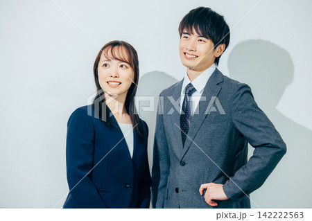 並んで立つスーツ姿の男女 142222563