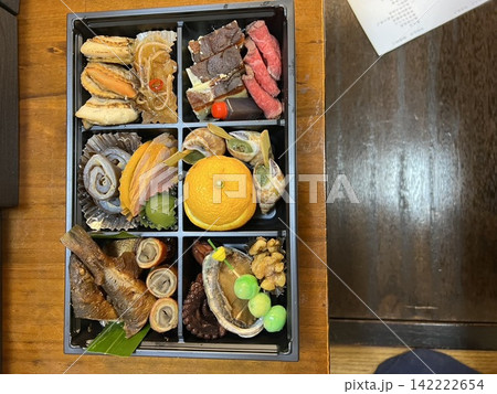 彩り豊かなおせち料理を重箱に詰めた、華やかな正月料理。日本の伝統的な祝い膳を真上から撮影した俯瞰写真 彩り豊かなおせち料理を重箱に詰めた、華やかな正月料理。日本の伝統的な祝い膳を真上から撮影した俯瞰写真 142222654