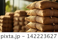 Stacked Burlap Sacks of Soybeans in a Warehouse with Emphasis on Texture and Rustic Appearance 142223627