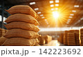 Stacked Rice Sacks in a Sunlit Warehouse Interior 142223692