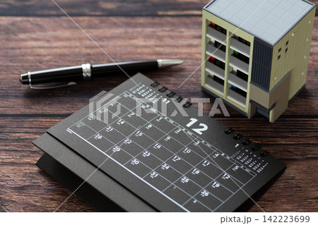 12月の黒いカレンダーとマンションの住宅模型 142223699