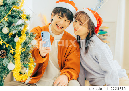 クリスマスの飾り付けをするカップル クリスマスの飾り付けをするカップル 142223713