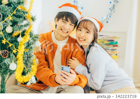 クリスマスの飾り付けをするカップル クリスマスの飾り付けをするカップル 142223719