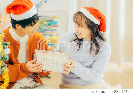 クリスマスプレゼントを渡すカップル クリスマスプレゼントを渡すカップル 142223723