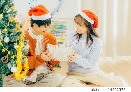 クリスマスプレゼントを渡すカップル クリスマスプレゼントを渡すカップル 142223724