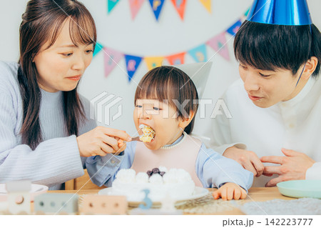 手作りの誕生日ケーキを家族3人で楽しむ親子 手作りの誕生日ケーキを家族3人で楽しむ親子 142223777