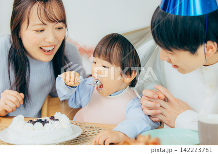 手作りの誕生日ケーキを家族3人で楽しむ親子 手作りの誕生日ケーキを家族3人で楽しむ親子 142223781