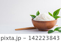 Wooden Bowl of Steamed White Rice with Chopsticks in Minimalist Setting 142223843
