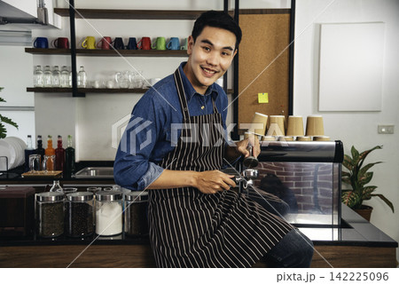 Portrait Barista small business Owner. Asian barista man coffee shop owner smiling look at camera small business confident person Entrepreneur manager professional men standing coffee counter bar 142225096