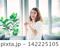 Happy asian dancing woman use headphones listen to music from smartphone happy dance in living room at home. Music mental therapist relaxation woman. Cheerful wellness women dance exercise wellbeing 142225105