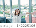Relax woman yawning sitting on cozy sofa in apartment. Asian woman relax stretching arm laziness comfortable in living room. Happiness girl lifestyles sitting at home living room. Stretching arm relax 142225106