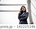 Portrait Businesswoman arms crossed smiling look at camera in modern city background. Happy Business people positive achievement standing and smile. Happy leader executive young asian women leader 142225146