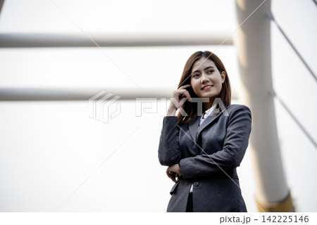 Portrait Businesswoman arms crossed smiling look at camera in modern city background. Happy Business people positive achievement standing and smile. Happy leader executive young asian women leader 142225146