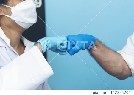 Two caucasian scientist men woman fist bump team partner shake hands together. Teamwork two scientist science chemistry research in laboratory. Close up hands pharmaceutical science team partnership Two caucasian scientist men woman fist bump team partner shake hands together. Teamwork two scientist science chemistry research in laboratory. Close up hands pharmaceutical science team partnership 142225204