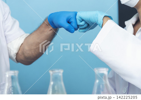 Two caucasian scientist men woman fist bump team partner shake hands together. Teamwork two scientist science chemistry research in laboratory. Close up hands pharmaceutical science team partnership Two caucasian scientist men woman fist bump team partner shake hands together. Teamwork two scientist science chemistry research in laboratory. Close up hands pharmaceutical science team partnership 142225205