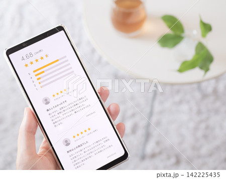 スマートフォンに表示された口コミや商品レビューの写真(スマホ画面はオリジナル制作) スマートフォンに表示された口コミや商品レビューの写真(スマホ画面はオリジナル制作) 142225435