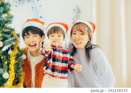 クリスマスツリーの飾り付けをする親子 クリスマスツリーの飾り付けをする親子 142226535