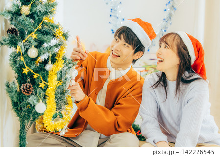 クリスマスの飾り付けをするカップル クリスマスの飾り付けをするカップル 142226545
