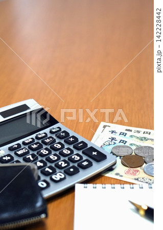 上部に余白がある電卓とお金とメモ帳の家計管理イメージ 142228442