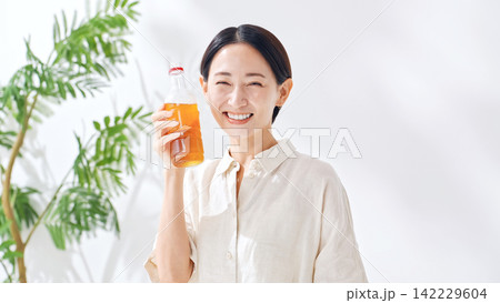 ペットボトルのお茶を飲む女性。水分補給、ウーロン茶、緑茶、紅茶、麦茶、水分補給、飲み物、ジュース ペットボトルのお茶を飲む女性。水分補給、ウーロン茶、緑茶、紅茶、麦茶、水分補給、飲み物、ジュース 142229604