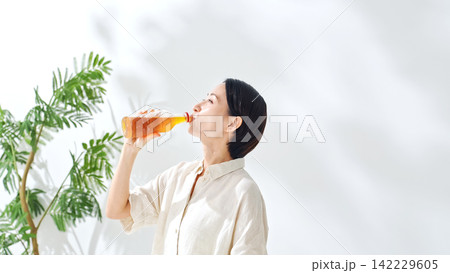 ペットボトルのお茶を飲む女性。水分補給、ウーロン茶、緑茶、紅茶、麦茶、水分補給、飲み物、ジュース 142229605