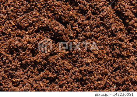 Dense Layer Of Coffee Grounds Filling Frame In Close Up Showing Compact Brown Granules Coarse 142230051