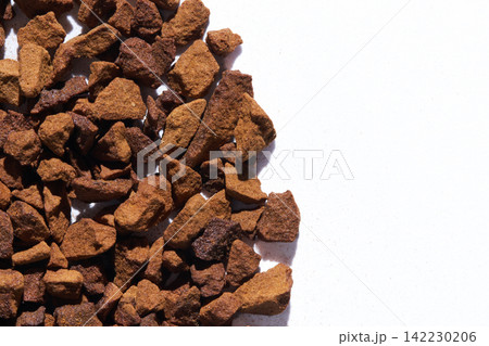 Instant Coffee Granules Scattered On White Studio Background Closeup Showing Rough Brown Texture Instant Coffee Granules Scattered On White Studio Background Closeup Showing Rough Brown Texture 142230206