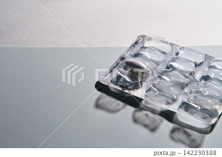 Blister Pack With Single Tablet Remaining On Reflective Pale Surface Casting Soft Shadow 142230388