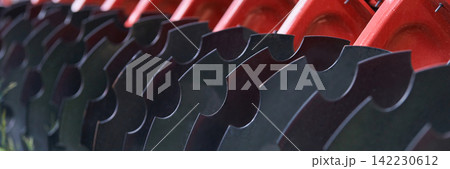 Agricultural Disc Harrow Blades Aligned On Red Frame In Close Up Detail Showing Curved Steel Discs Agricultural Disc Harrow Blades Aligned On Red Frame In Close Up Detail Showing Curved Steel Discs 142230612
