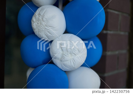 Blue White Balloons Clustered And Tied Against Brick Wall On Building Exterior Close-Up Decorative 142230756