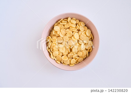 Bowl Of Corn Flakes In Pink Ceramic Bowl Overhead View On White Table For Breakfast Minimalist Bowl Of Corn Flakes In Pink Ceramic Bowl Overhead View On White Table For Breakfast Minimalist 142230820