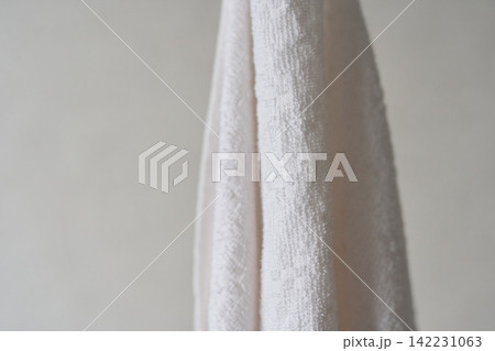 White Terry Towel Hanging Vertically Showing Textured Fabric Loops And Plush Surface Against 142231063