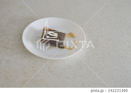 Used Paper Drip Coffee Filter Resting On White Plate With Coffee Stains On Speckled Countertop 142231360