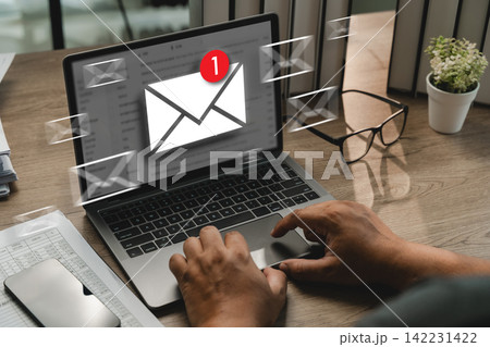 Hands checking email notification on laptop with floating mail icons, showing new email alert, inbox message update, digital communication, online notification, office workspace. 142231422