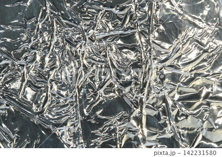 Crumpled Metallic Foil Texture Background With Silver Wrinkles And Reflective Highlights For Design Crumpled Metallic Foil Texture Background With Silver Wrinkles And Reflective Highlights For Design 142231580