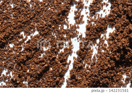 Dense Spread Of Ground Coffee Crumbs Forming Textured Rows On White Background Closeup Emphasizing Dense Spread Of Ground Coffee Crumbs Forming Textured Rows On White Background Closeup Emphasizing 142231581