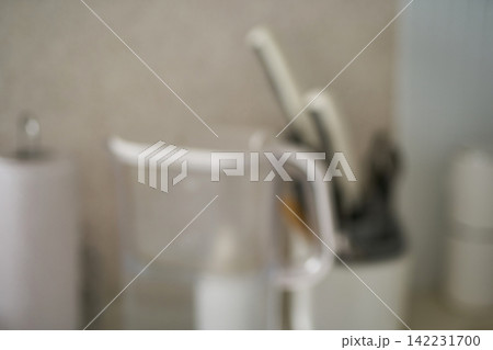 Kitchen Countertop Automatic Soap Dispenser And Utensil Holder In Blurred Domestic Sink Area Kitchen Countertop Automatic Soap Dispenser And Utensil Holder In Blurred Domestic Sink Area 142231700