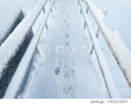 Snow Ramp With Footprints Between Rusted Metal Railings On Urban Outdoor Walkway After Fresh 142231827