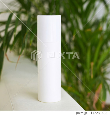 White Cylindrical Skincare Bottle Standing Upright Placed On Couch Edge With Green Houseplant 142231898