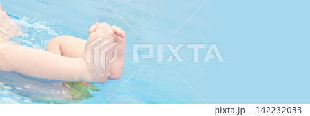 Baby Feet Floating And Kicking Near Pool Edge With Small Ripples On Shallow Water And Pale Blue Baby Feet Floating And Kicking Near Pool Edge With Small Ripples On Shallow Water And Pale Blue 142232033