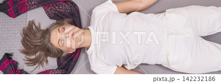 Woman Lying On Mat With Relaxed Posture And Hair Spread Around Head With Scarf Creating Calm 142232186