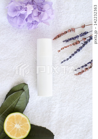 Natural skincare concept with cream bottle, lavender, hydrangea, leaves, and citrus on white Natural skincare concept with cream bottle, lavender, hydrangea, leaves, and citrus on white 142232363